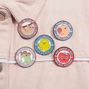 Detailed view of 5 colorful animal enamel pins on denim, including sloth and capybara designs