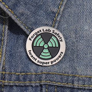 Science Enamel Pin with green glitter radioactive symbol on blue denim jacket