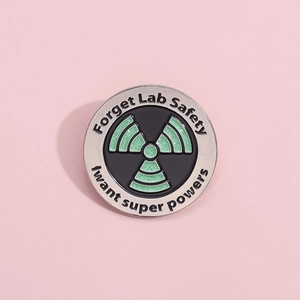 Macro view of the science enamel pin showing the lab safety slogan and radioactive symbol