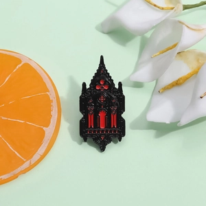 Gothic castle emblem brooch with red and black enamel detail on green background