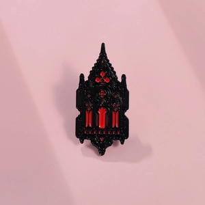 Detailed view of Gothic castle brooch with red and black enamel in medieval window style