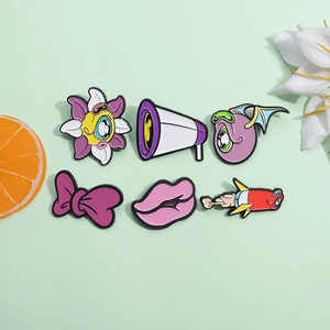 Set of 6 cartoon monster enamel pins including floral and rocket designs on green background