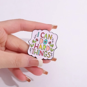 Enamel lapel pin with I CAN DO HARD THINGS quote and floral details on purple background