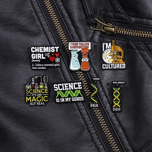 Detail showing colorful science and DNA enamel pins on a black leather jacket texture