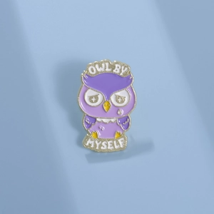 Cute purple enamel owl brooch with golden trim and 'Owl By Myself' text on blue background