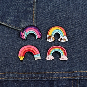 Vier süße Regenbogen-Emaille-Pins mit Katzen- und Wolkenmotiven auf Denim-Stoff