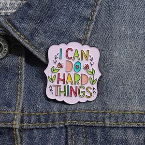 Inspirational enamel brooch with I CAN DO HARD THINGS quote on blue denim jacket