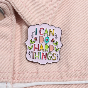 Enamel pin with I CAN DO HARD THINGS quote on pink denim jacket collar