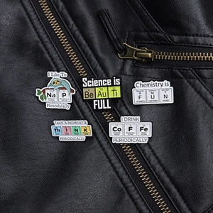 Detailed close-up of five scientific enamel pins featuring chemistry puns on black leather