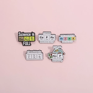 5-piece science enamel pin set featuring periodic table puns on a pink background