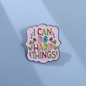 Enamel brooch pin featuring 'I CAN DO HARD THINGS' text with colorful flowers and leaves