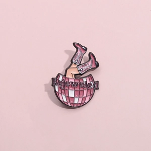 Détail de la broche en émail rose avec boule disco, bottes de cow-boy et texte Bejeweled