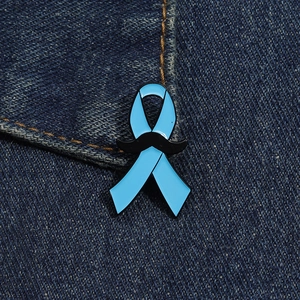 Détail du pin's ruban bleu avec moustache sur fond de tissu en denim bleu foncé