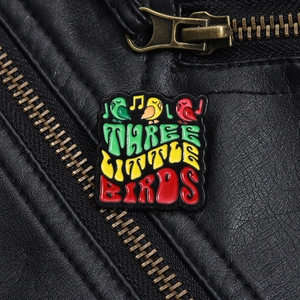 Detailansicht der Three Little Birds Emaille-Anstecknadel auf schwarzer Lederjacke