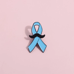 Détail macro de l'épingle en émail ruban bleu avec moustache noire pour sensibilisation