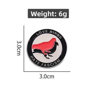 Detail showing 3.0cm enamel pin with Love Birds Hate Fascism text on white background