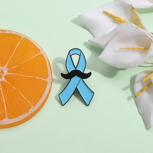 Détail d'une épinglette en émail ruban bleu avec moustache noire pour la santé des hommes