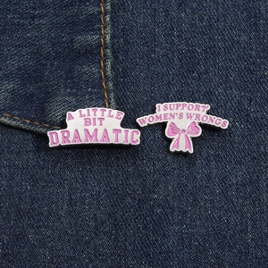 Pins en émail rose avec slogans et nœud papillon sur tissu en denim bleu