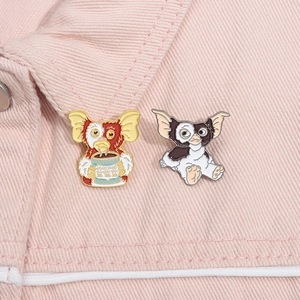 Detail of Gremlins Gizmo enamel pins on pink denim jacket showing intricate painted metal