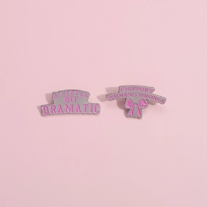 Broches en émail rose avec slogans et nœud décoratif avec des bords en métal argenté poli