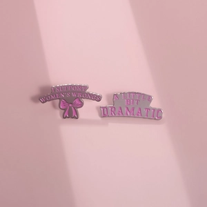Gros plan détaillé de pins en émail rose avec slogans féministes et motif de nœud
