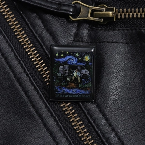 Detail of artistic enamel brooch on leather jacket showing starry sky van life design