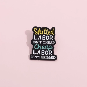 Vue détaillée d'une broche en émail avec texte multicolore sur fond rose pastel