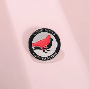Round enamel brooch with double bird silhouette and Love Birbs Hate Fascism slogan
