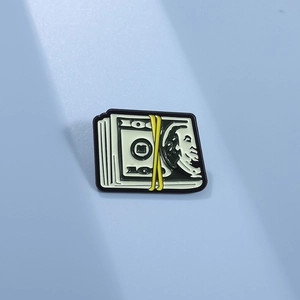 Détail macro du pin's émaillé en forme de liasse de dollars avec gravure réaliste 100