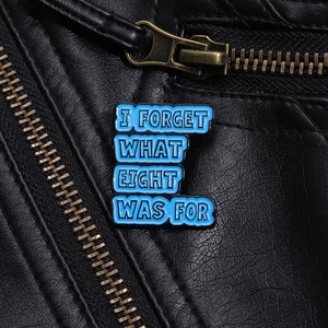 Close-up of blue enamel pin with text on a black leather jacket collar accessory