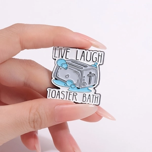 Funny toaster bath enamel pin with Live Laugh Toaster Bath letters in hand