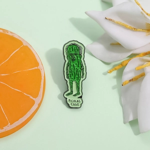 Funny Picolas Cage green cucumber enamel pin badge with quirky face design on green background