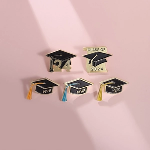 Detail of 2025 graduation enamel pins with mortarboard designs and gold finish