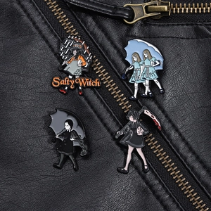 Detail of Gothic enamel pins on a black leather jacket featuring spooky film characters