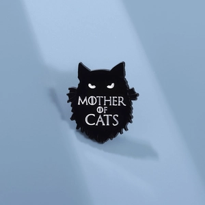 Dettaglio di una spilla in smalto a gatto nero con testo Mother of Cats su sfondo azzurro