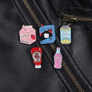 Set of five colorful enamel pins with cartoon milk and juice designs on a leather jacket