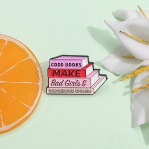 Broche pile de livres en émail rose avec texte Bad Girls et Dangerous Women sur fond vert
