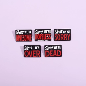 Set of 5 minimalist black enamel pins with creative red and white text on purple background