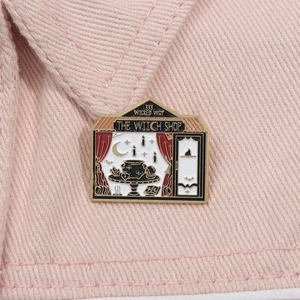 Gros plan sur le pin's The Witch Shop avec texte 333 Wicked Way sur du denim rose pastel