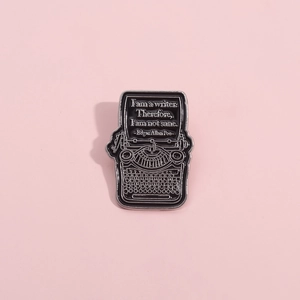 Retro typewriter enamel pin with literary quote on a pink background for writers