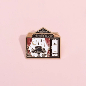 Broche émaillée boutique de sorcière noire et blanche avec motifs lune étoiles et or