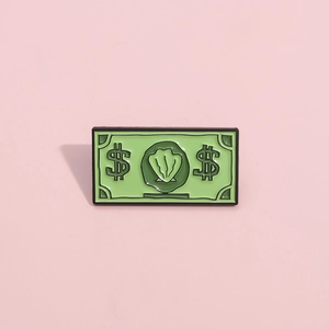 Détail de l'épinglette en émail en forme de billet vert avec motif coquillage et bord noir