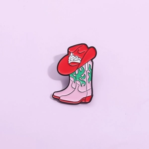 Pink cowboy boot and red hat enamel pin featuring crown and green flame patterns