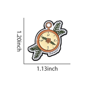 Détail d'une broche émaillée boussole fleurie avec gravure biblique Jérémie 29:11