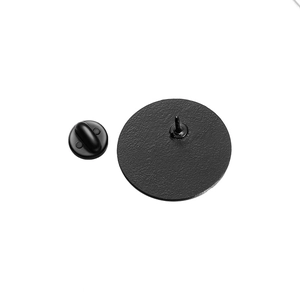 Detail of round black metal badge back with needle and matching rubber clutch closure