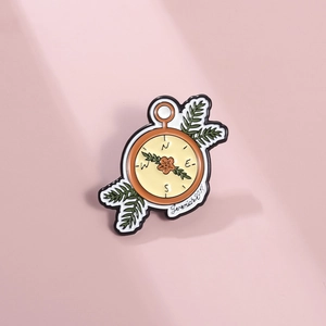 Détail de la broche boussole émaillée avec fleurs orange et texte Jeremiah 29:11