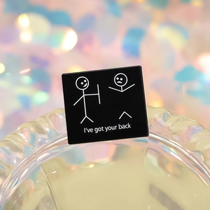 Minimalist square enamel brooch with I've Got Your Back text and stick figure art