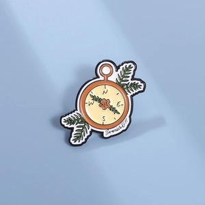 Détail d'un pin's boussole émaillé avec fleurs et verset biblique Jérémie 29:11 gravé