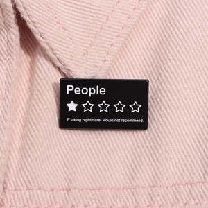 Gros plan d'une broche en émail noir avec un design ironique d'évaluation à une étoile