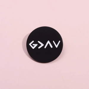 Detail of round black enamel pin badge with white God is Greater symbols on pink background